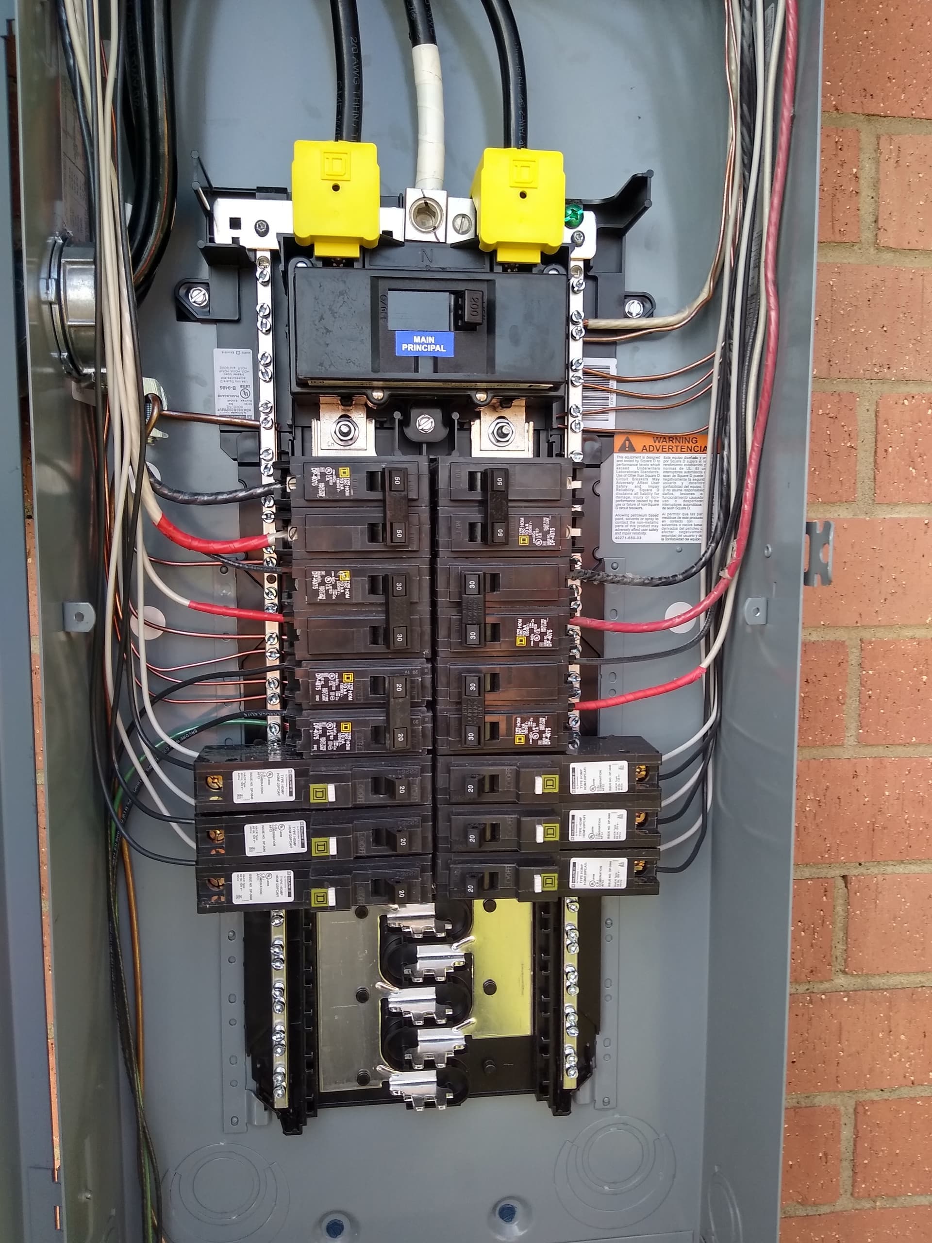 Open electrical panel showing the main breaker, multiple circuit breakers, and complex internal wiring.